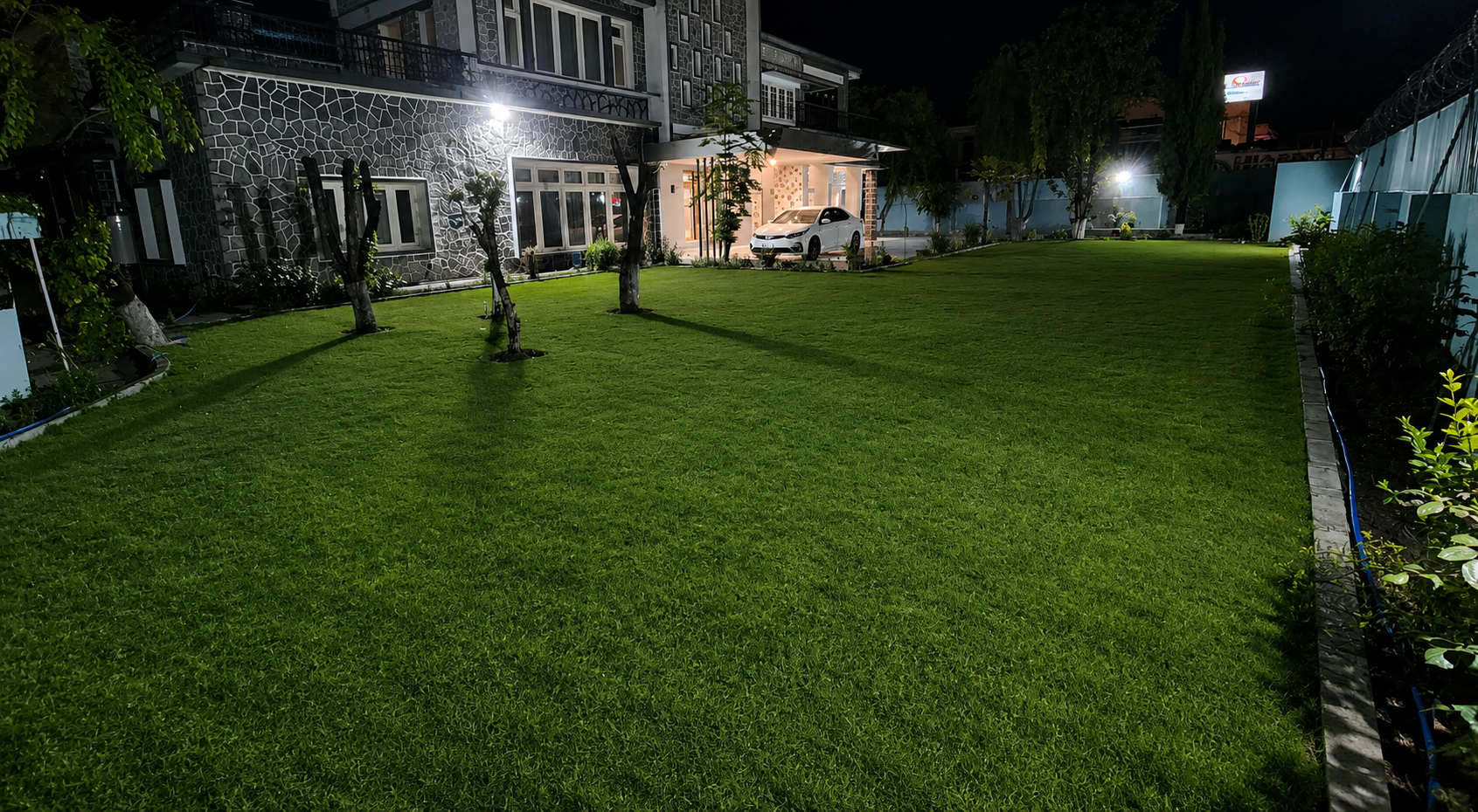 Jhangi House floodlit front lawn at night