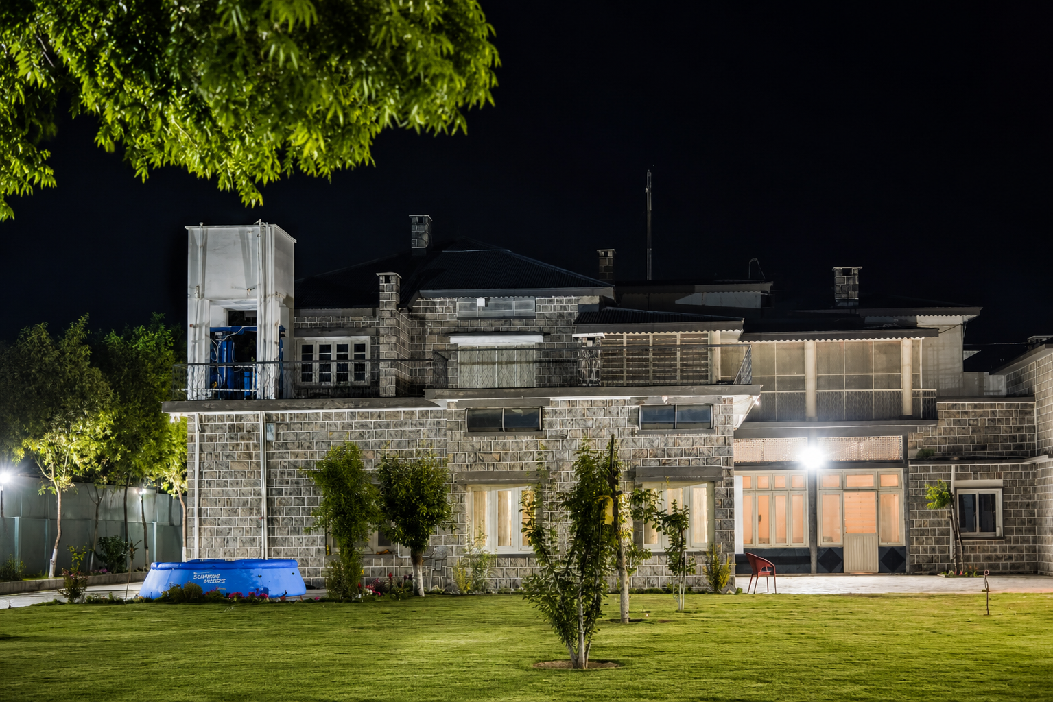 Jhangi House — rear facade at night with inflatable pool