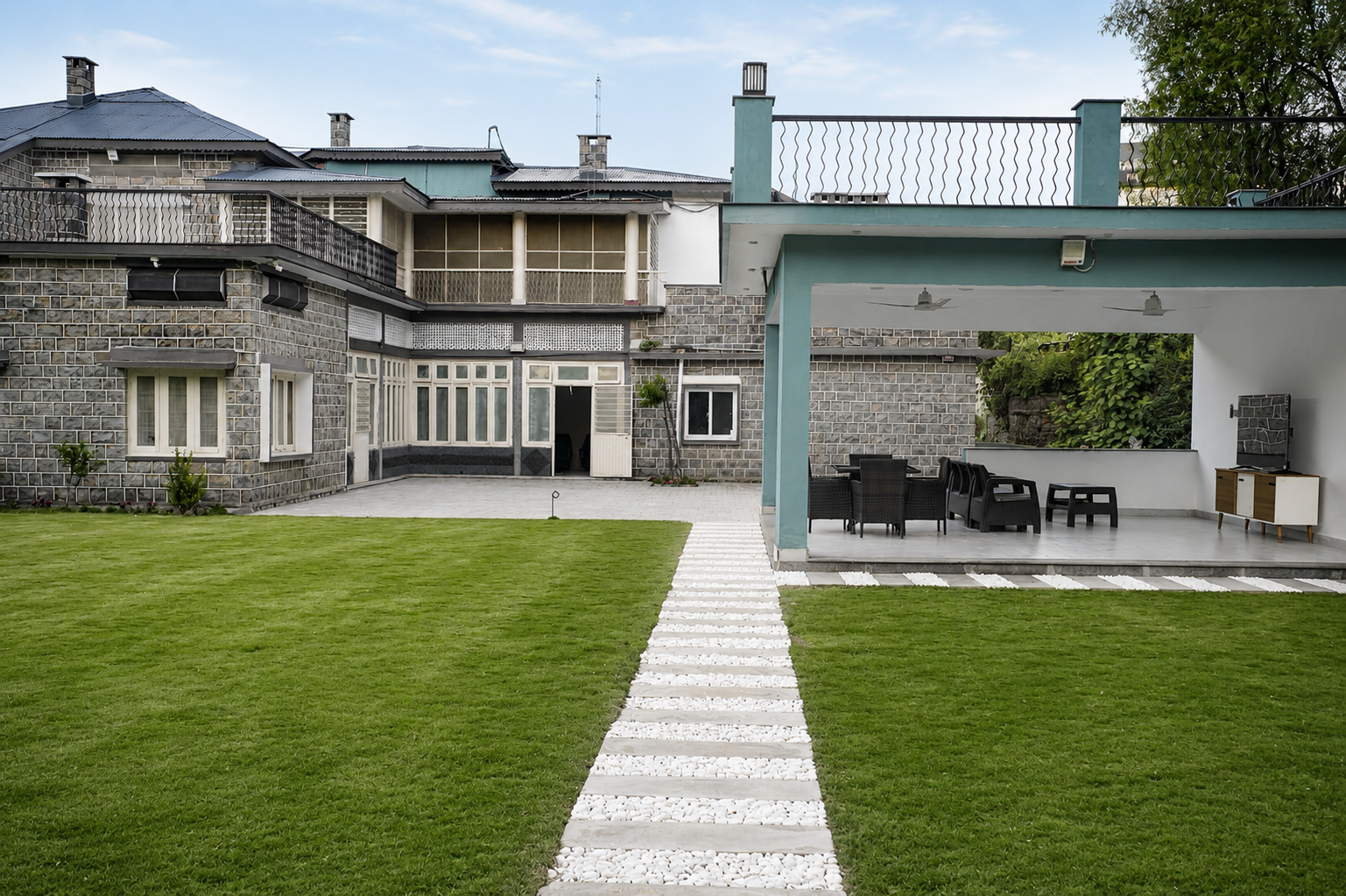 Outdoor pavilion with white pebble garden path through lush grounds